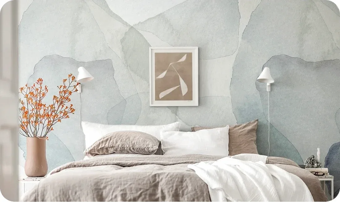A serene bedroom with an abstract watercolor-style wallpaper